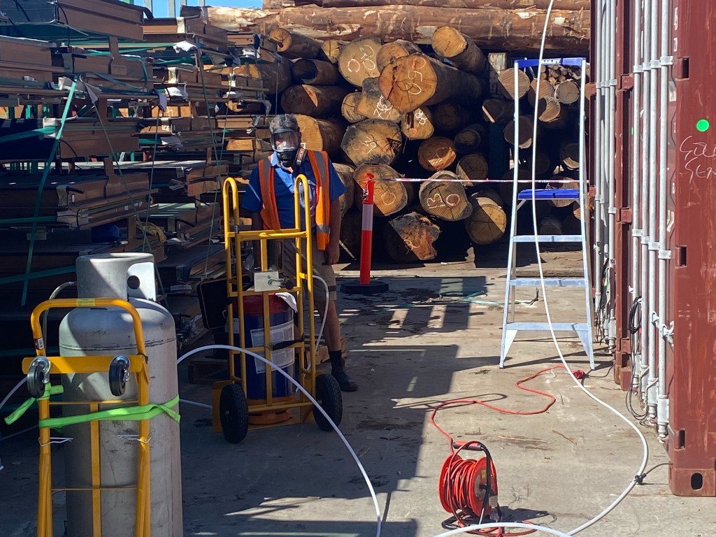 TFS on-site fumigation and gas monitoring equipment set up beside export logs and containers
