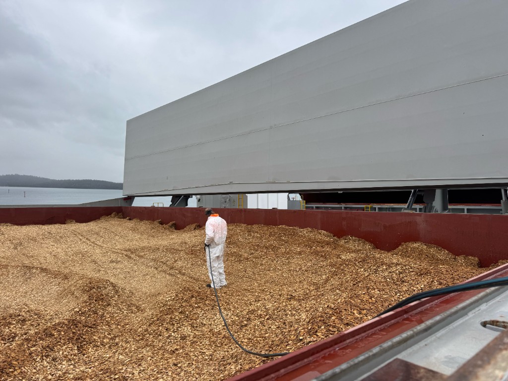 TFS crew treating the surface of a loaded woodchip hold